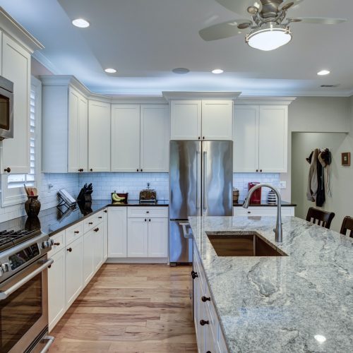 Beautiful luxury kitchen with quartz and granite countertops and white cabinets.